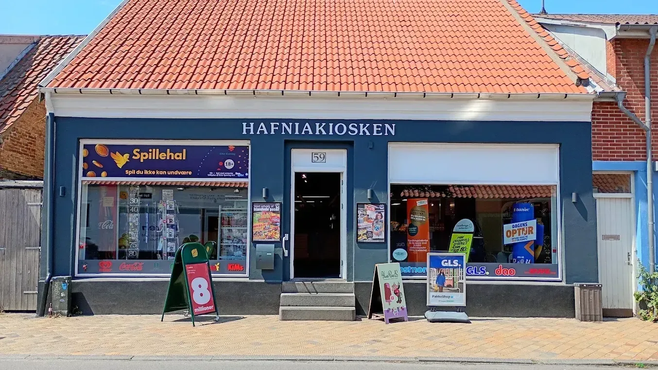Hafniakiosken-facaden på Store Torvegade i solskin, med pakkeudleveringsskilte